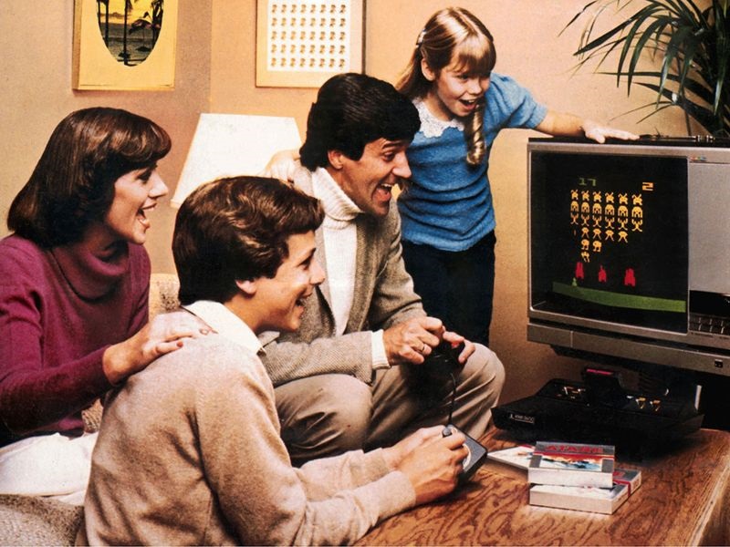 A family having fun playing the Atari 2600